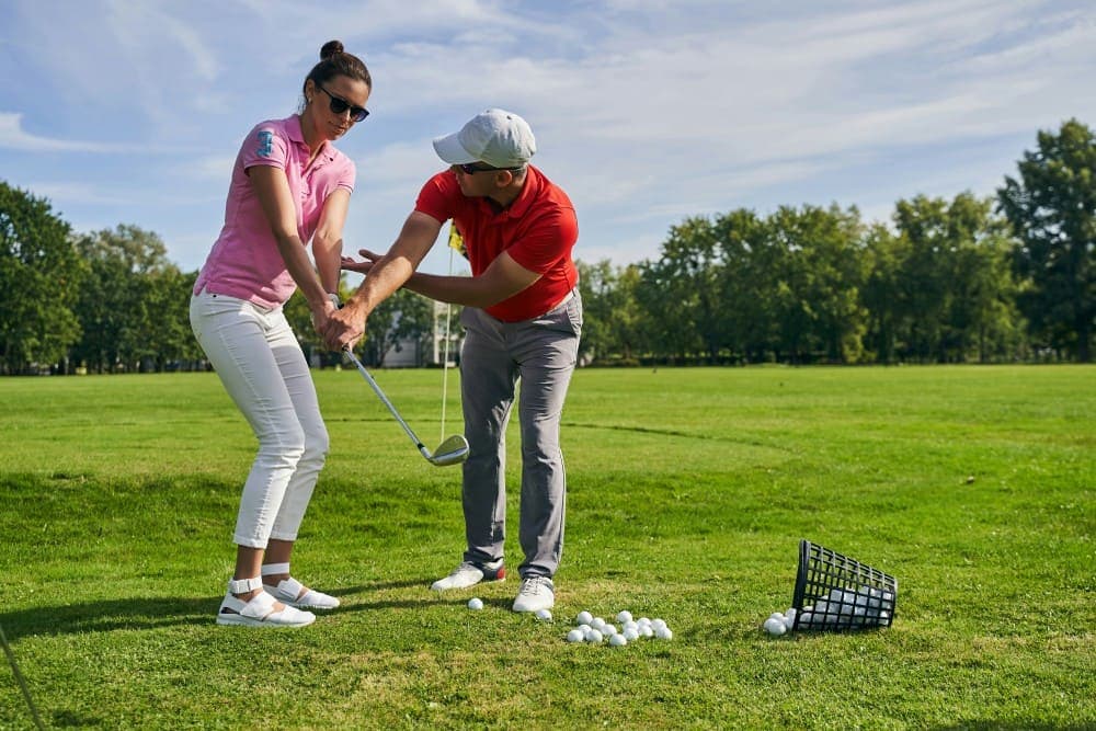 FAQ golf Coach professionnel apprenant les bases du swing à une golfeuse débutante