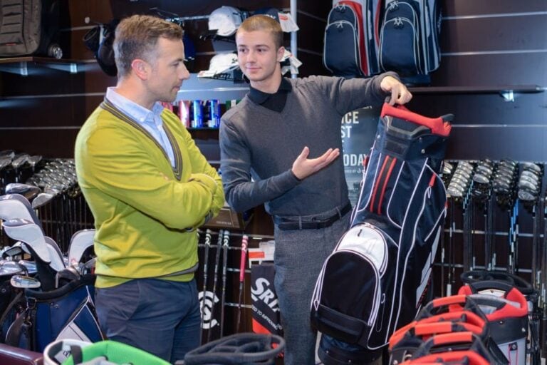 Golfeur avec un vendeur dans un magasin de matériel de golf