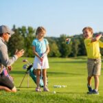 Parent expliquant à ses enfants comment débuter golf enfant