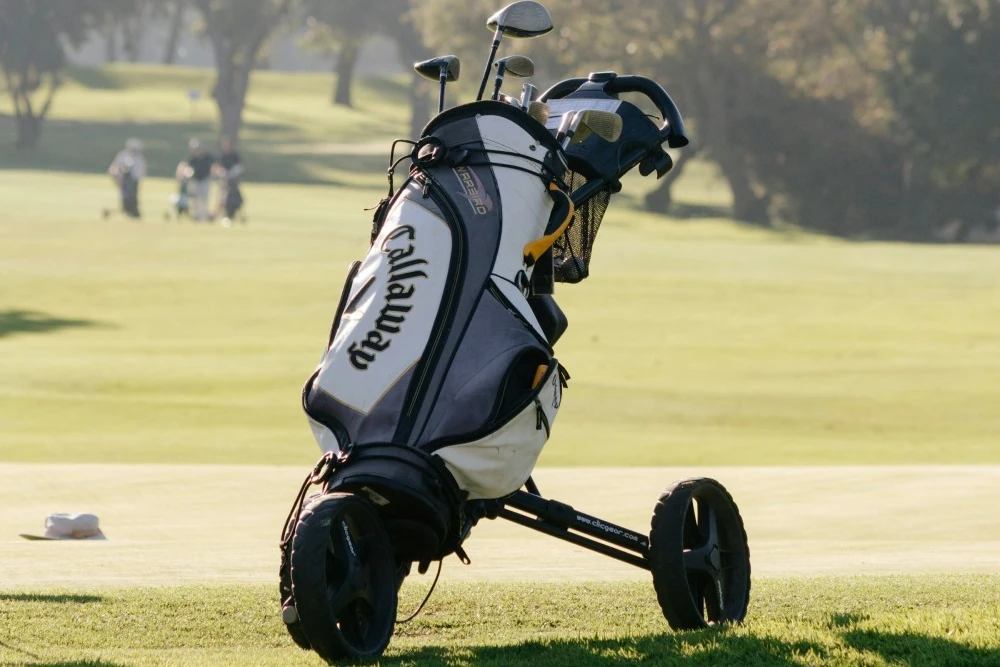 Golfeur avec chariot de golf électrique sur fairway vallonné — choisir chariot électrique golf 2026