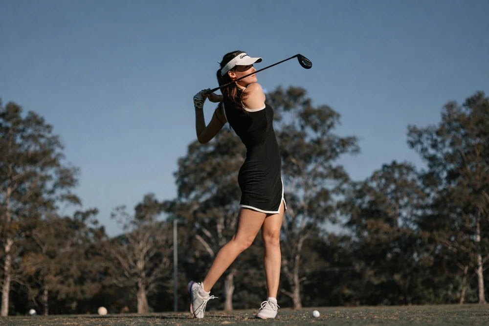 Golfeuse en polo et jupe technique sur le green – tenue golf femme code vestimentaire