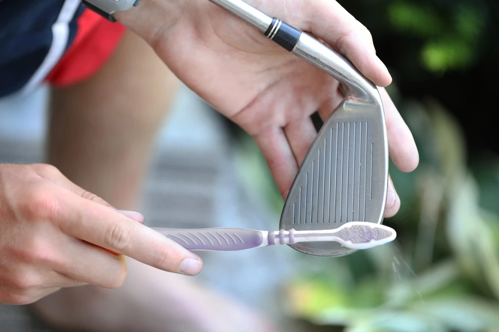 Nettoyage des stries d'un fer avec une brosse, entretien des clubs golf occasion