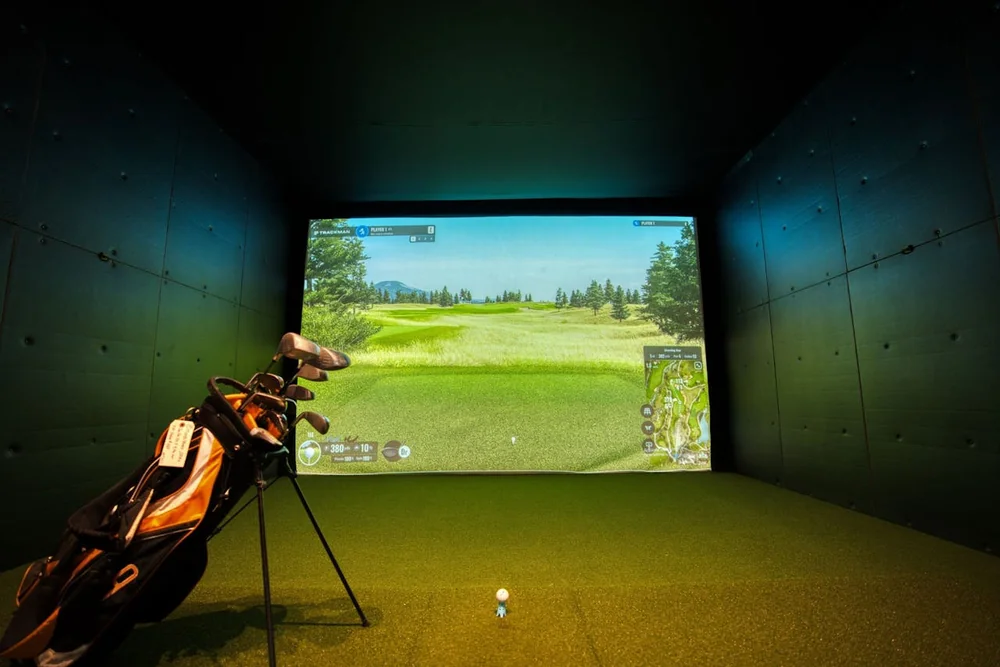 Simulateur de fitting de golf avec écran TrackMan et sac de clubs pour analyser le swing et choisir ses fers