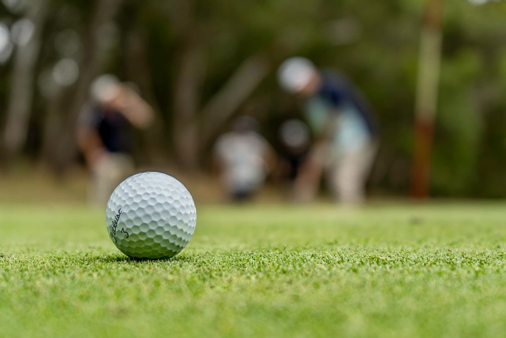Putter noir face à la balle sur green pour pratiquer les exercices de putting structurés