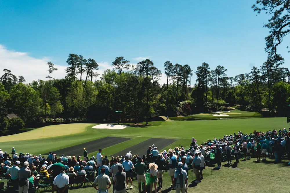 LIV Golf : un joueur putte sur un green entouré de spectateurs.